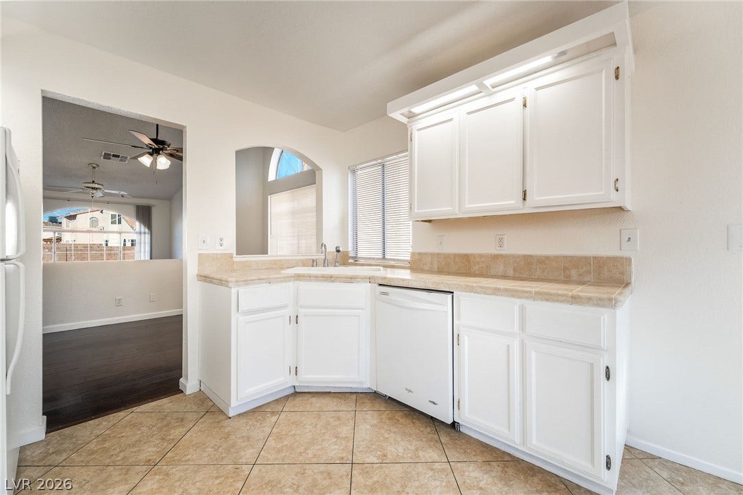 768 Panhandle Drive, Henderson, NV 89014 Tiled flooring and matching countertops define this bright kitchen space with a pass-through window.