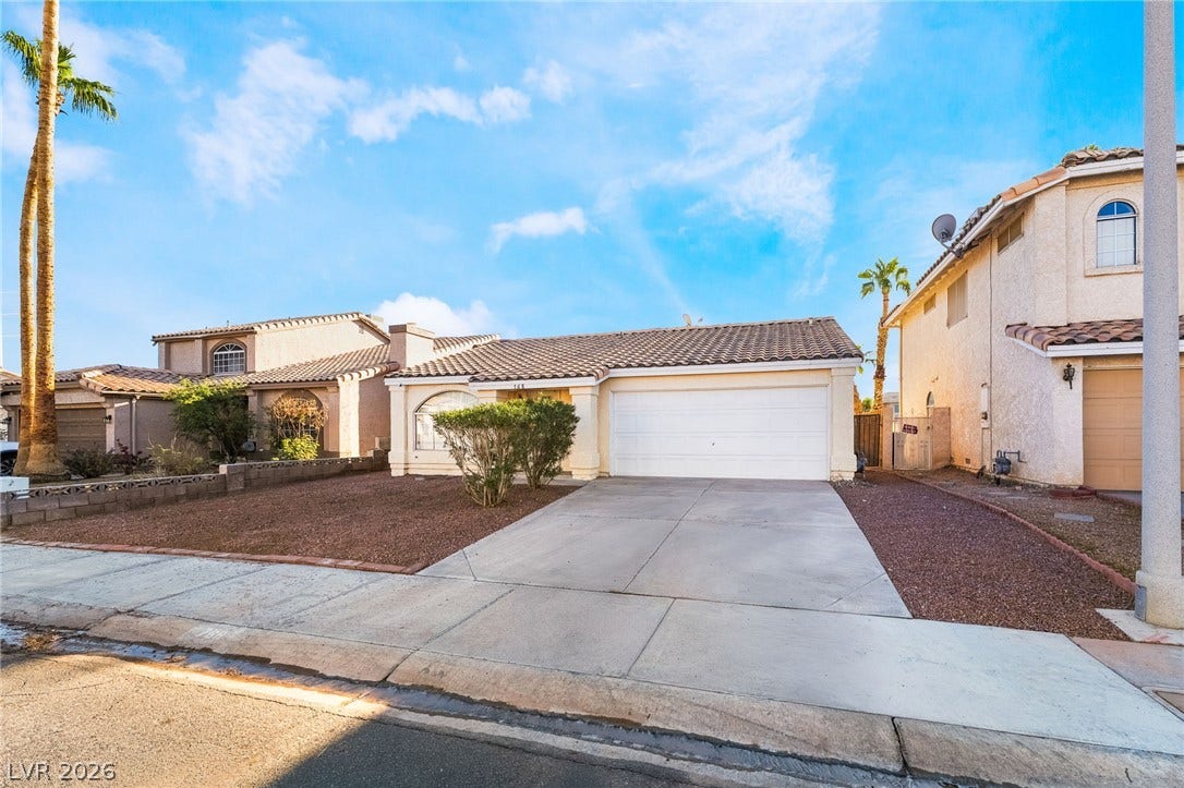 768 Panhandle Drive, Henderson, NV 89014 A wide concrete driveway leads to the attached two-car garage of this stucco-finished home.