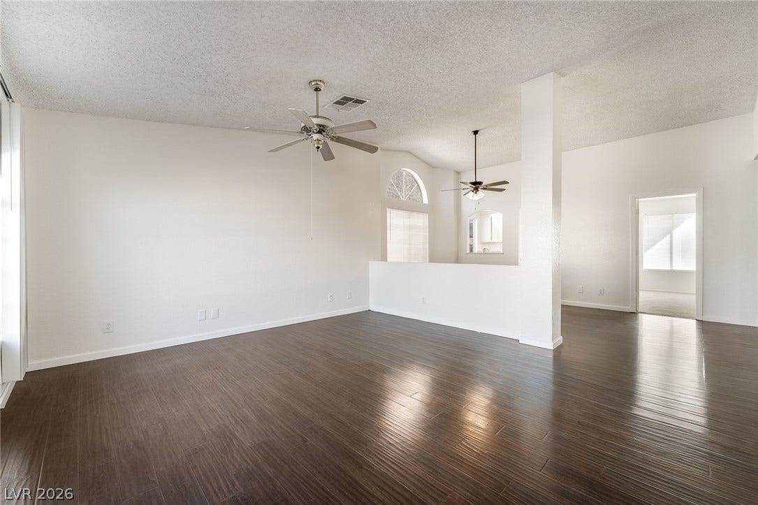 768 Panhandle Drive, Henderson, NV 89014 Rich dark wood-style flooring and high vaulted ceilings define this open and versatile living space.