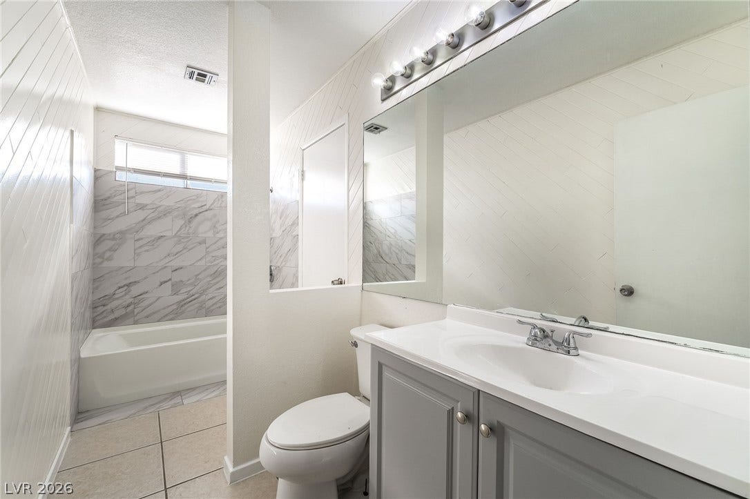 768 Panhandle Drive, Henderson, NV 89014 Marble-patterned wall tile pairs with sleek vanity cabinetry in this updated bathroom.