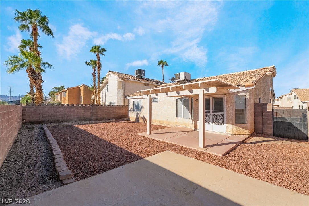 768 Panhandle Drive, Henderson, NV 89014 A spacious backyard features a covered concrete patio, low-maintenance gravel landscaping, and privacy fencing.