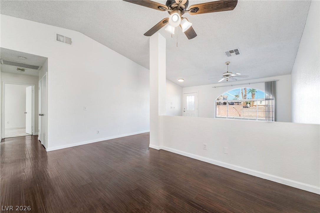 768 Panhandle Drive, Henderson, NV 89014 Rich wood-inspired flooring pairs with towering vaulted ceilings in this airy living space.