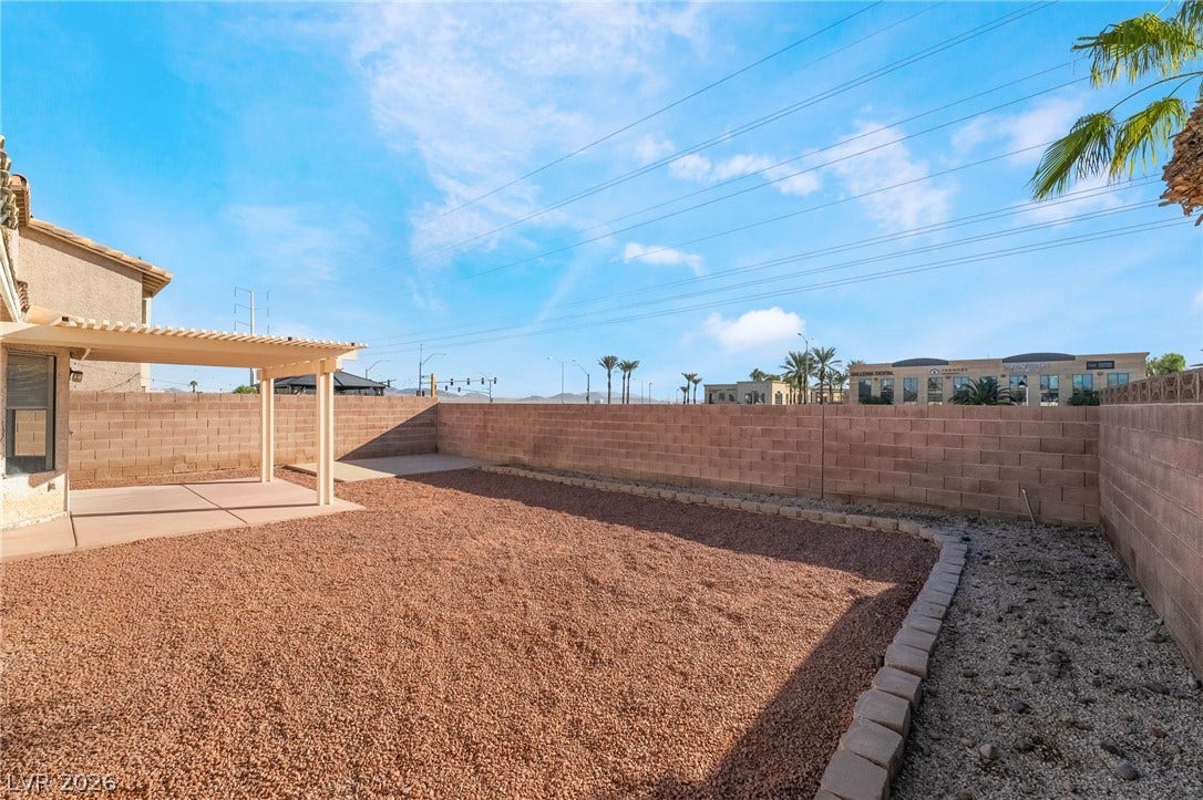 768 Panhandle Drive, Henderson, NV 89014 High block walls secure a low-maintenance gravel yard with a shaded concrete patio.