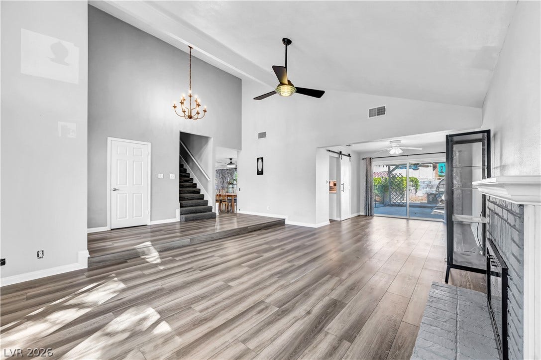 342 Fuente Drive, Henderson, NV 89014 High vaulted ceilings and rich wood-style flooring anchor this open main-level living space.