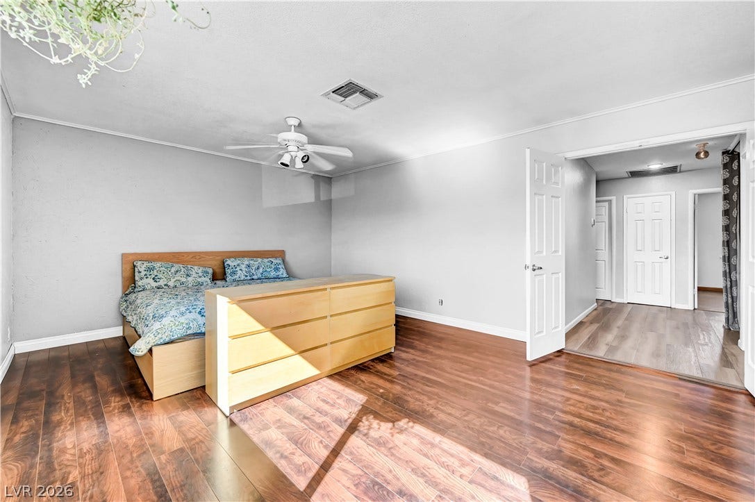 342 Fuente Drive, Henderson, NV 89014 Rich wood floors and a classic crown molding detail enhance this spacious bedroom layout.