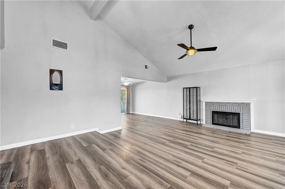 342 Fuente Drive, Henderson, NV 89014 Vaulted ceilings soar over durable wood-look flooring and a classic brick fireplace.