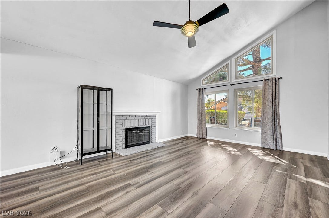 342 Fuente Drive, Henderson, NV 89014 Soaring vaulted ceilings and a brick fireplace highlight this inviting living room.