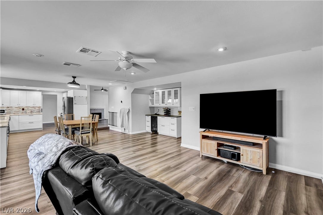 342 Fuente Drive, Henderson, NV 89014 Warm wood-look flooring stretches across a seamless, light-filled open layout connecting the main living areas.