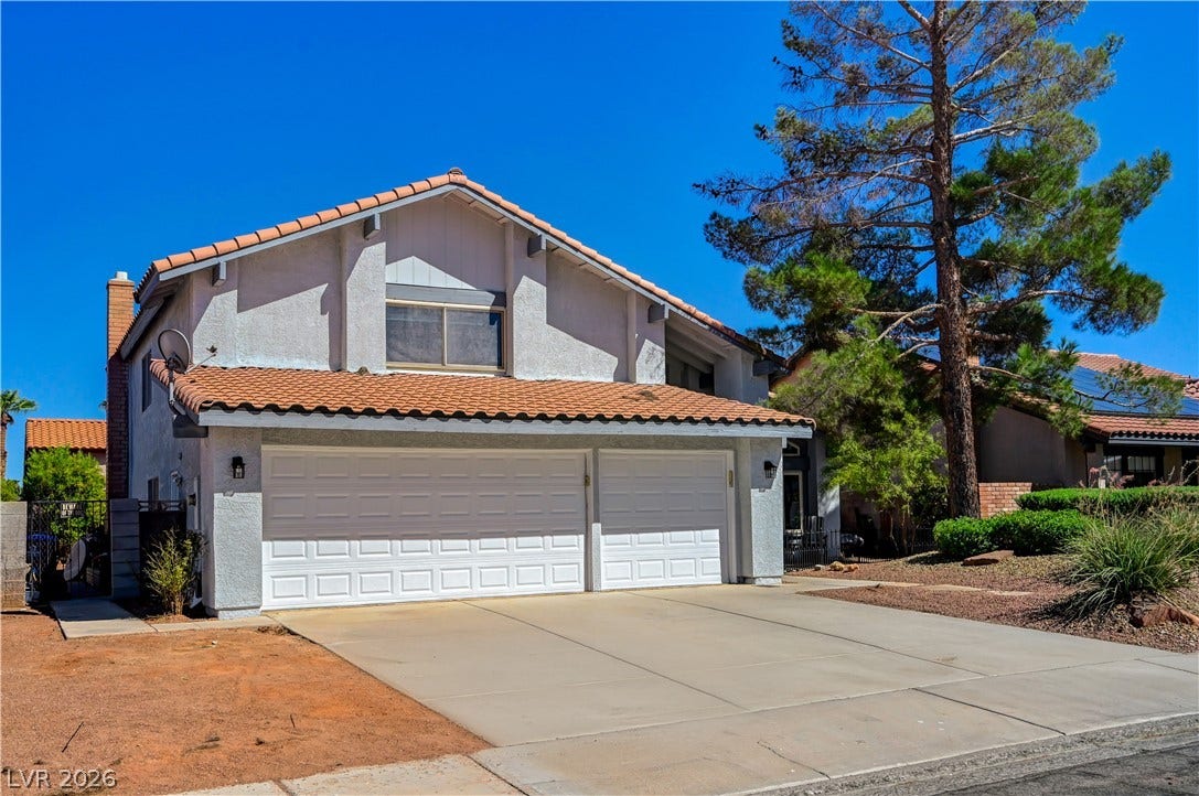 342 Fuente Drive, Henderson, NV 89014 A spacious concrete driveway leads to the multi-car garage of this multi-level stucco home.