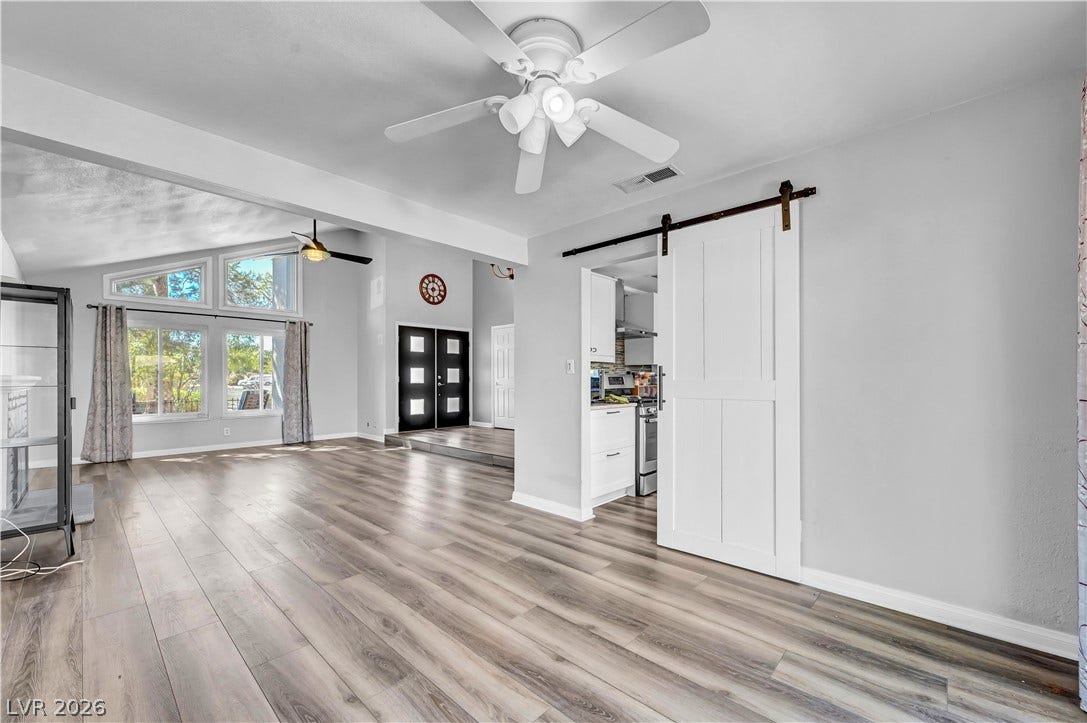 342 Fuente Drive, Henderson, NV 89014 Gleaming wood-look floors span an open-concept living area beneath vaulted ceilings.