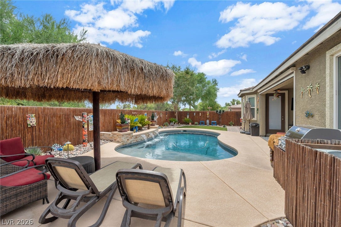 5652 Portage Lake Court, Las Vegas, NV 89130 A tranquil backyard oasis features a free-form pool with rock waterfalls and a thatched palapa for ultimate relaxation. Pool is newer built in 2020.