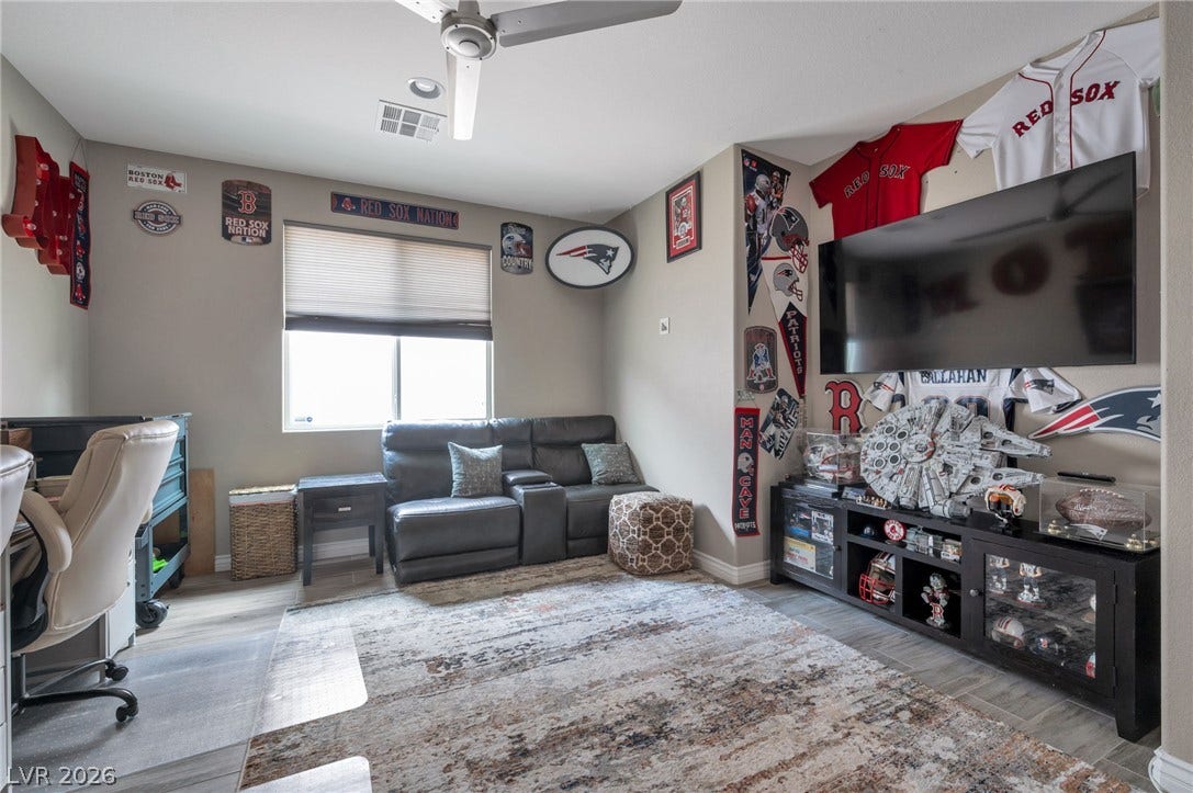 5652 Portage Lake Court, Las Vegas, NV 89130 A well-lit Den/bonus room features a comfortable seating area, sleek tile flooring, and a window with natural light.