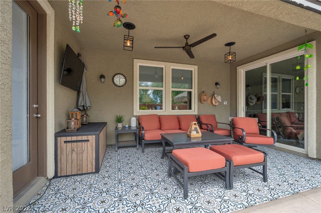 5652 Portage Lake Court, Las Vegas, NV 89130 An inviting covered patio offers a comfortable lounge with motorized screen for a totaly enclosed area and stylish patterned flooring.