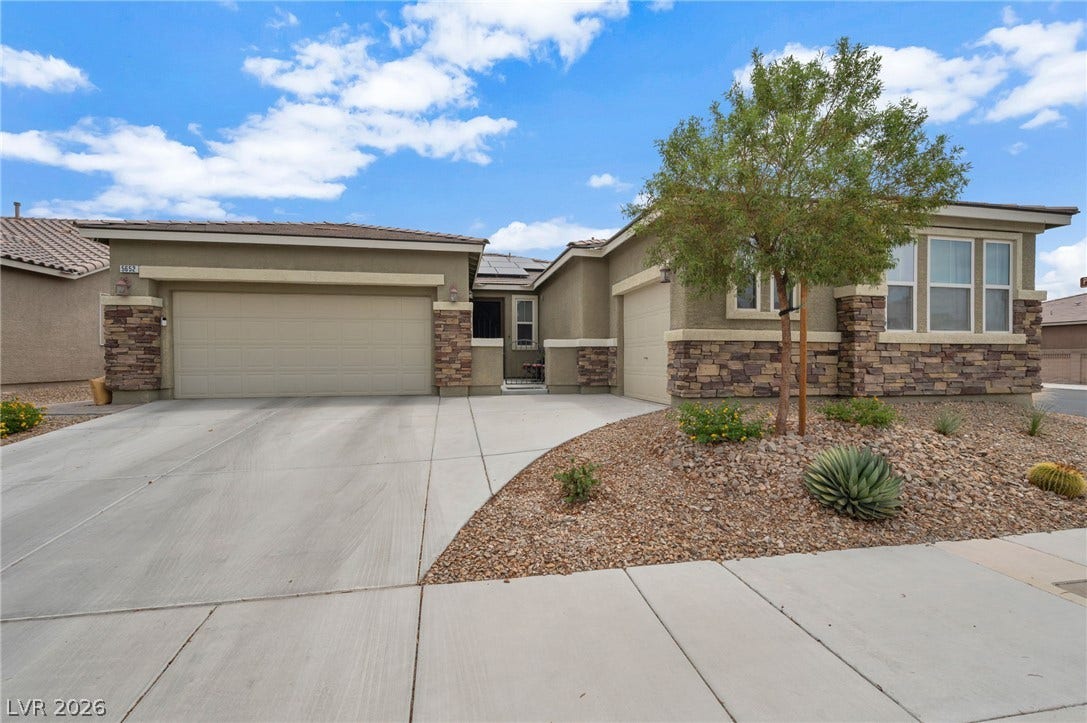 5652 Portage Lake Court, Las Vegas, NV 89130 A desert-friendly landscape frames this inviting single-story home with a wide concrete driveway and stacked stone accents.