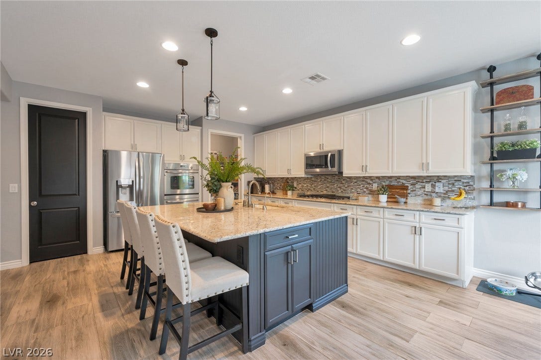 5652 Portage Lake Court, Las Vegas, NV 89130 A chef's dream kitchen with a large central island, granite countertops, and sleek stainless steel appliances.