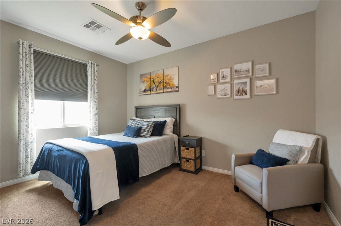 5652 Portage Lake Court, Las Vegas, NV 89130 A comfortable bedroom with soft carpeting and a ceiling fan, offering a tranquil retreat.
