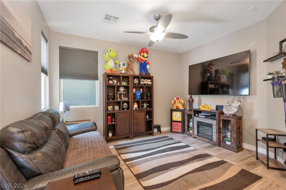 5652 Portage Lake Court, Las Vegas, NV 89130 Relax in this comfortable living area, featuring smooth flooring, a ceiling fan, and ample wall space.