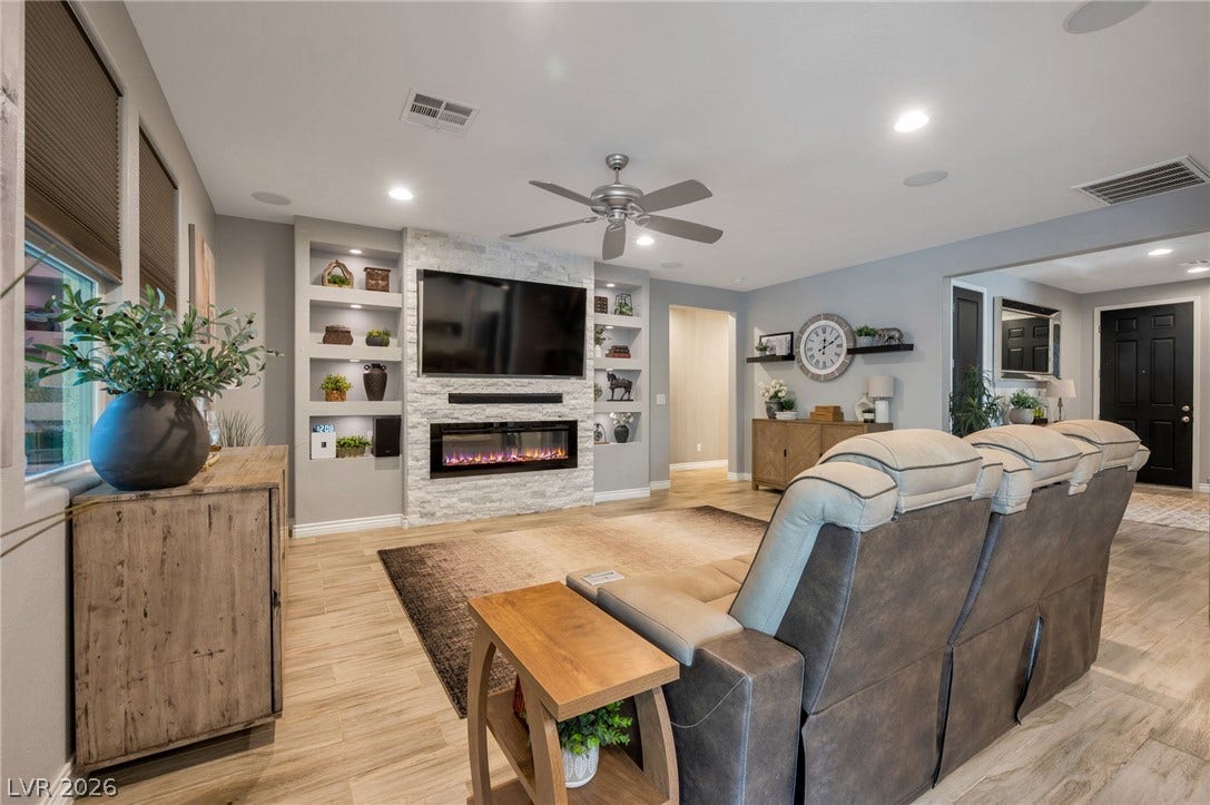 5652 Portage Lake Court, Las Vegas, NV 89130 A welcoming living room features built-in shelving, an inviting fireplace, and light wood flooring.