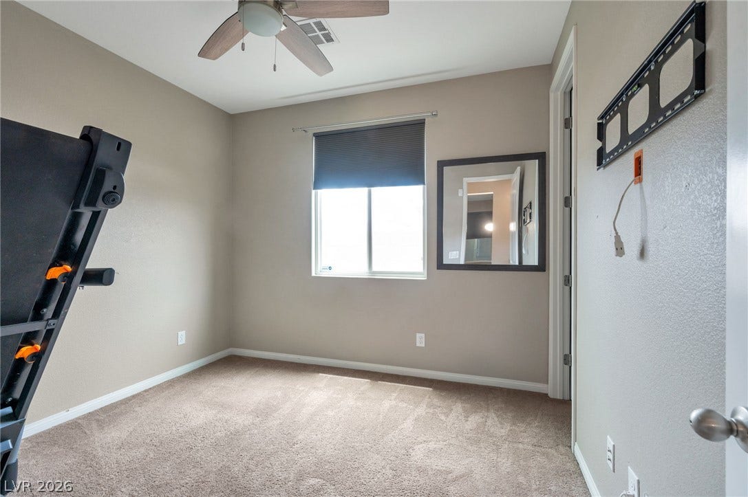 5652 Portage Lake Court, Las Vegas, NV 89130 Well-lit room features carpeted flooring and a ceiling fan for comfort.