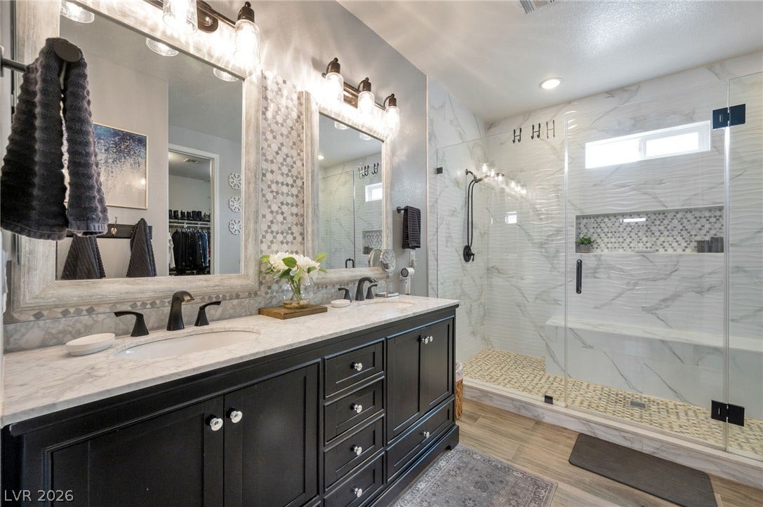 5652 Portage Lake Court, Las Vegas, NV 89130 Luxurious primary bathroom features a double vanity with a marble countertop and a spacious walk-in shower. Recently remodeled in August 2021.