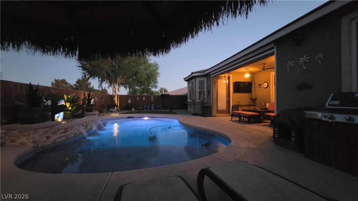 5652 Portage Lake Court, Las Vegas, NV 89130 An inviting backyard oasis offers a sparkling pool with water features and a covered patio for evening relaxation.