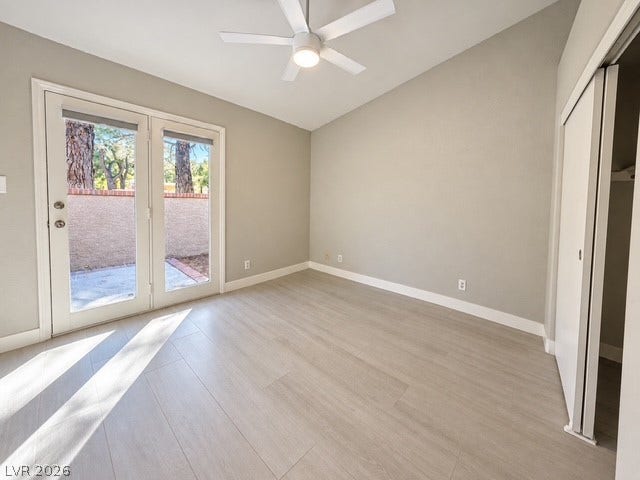 Vaulted ceilings and wide-plank flooring define this bright, versatile bedroom opening to a private patio.