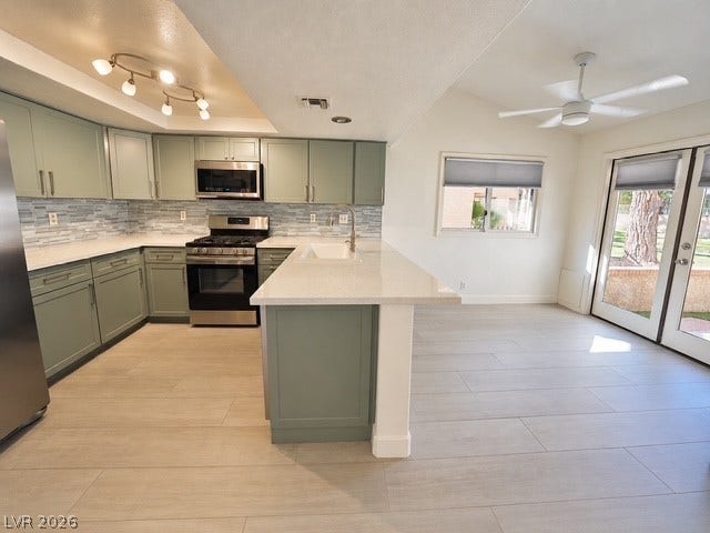 An open kitchen layout is enhanced by smooth stone countertops and light-toned tile flooring.