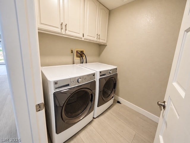 A dedicated laundry space features overhead cabinetry and tile flooring.