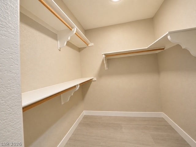 Ample built-in shelving and hanging rods maximize storage in this walk-in closet.
