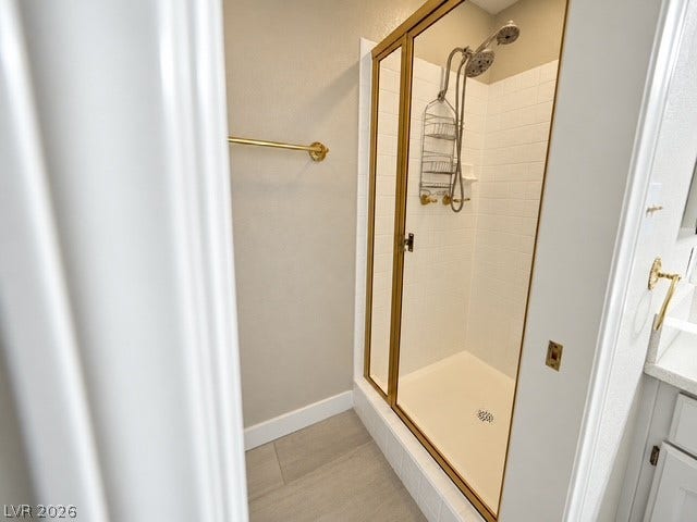 Tiled flooring and a gold-framed glass shower door define this bathroom space.