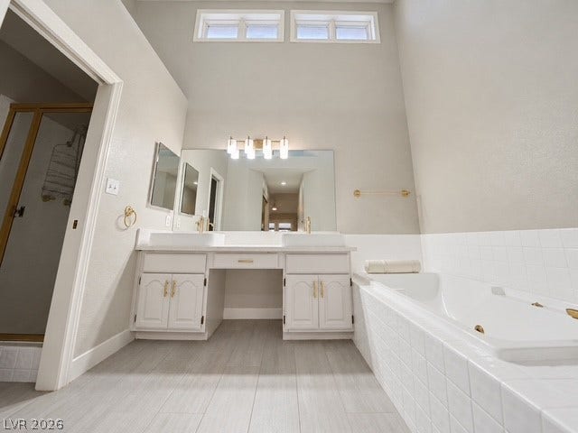 High ceilings and a deep soaking tub anchor this spacious primary bath.