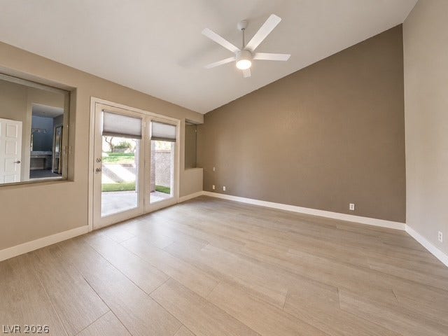 French doors open to the patio from this room with a vaulted ceiling.
