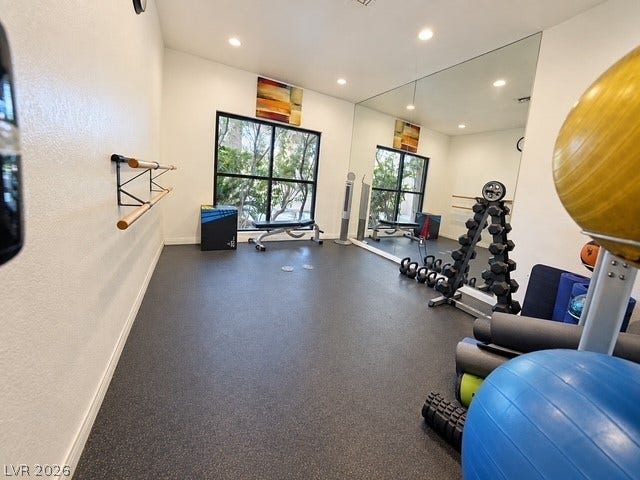 Recessed lighting and a wall of mirrors enhance this dedicated home fitness space.