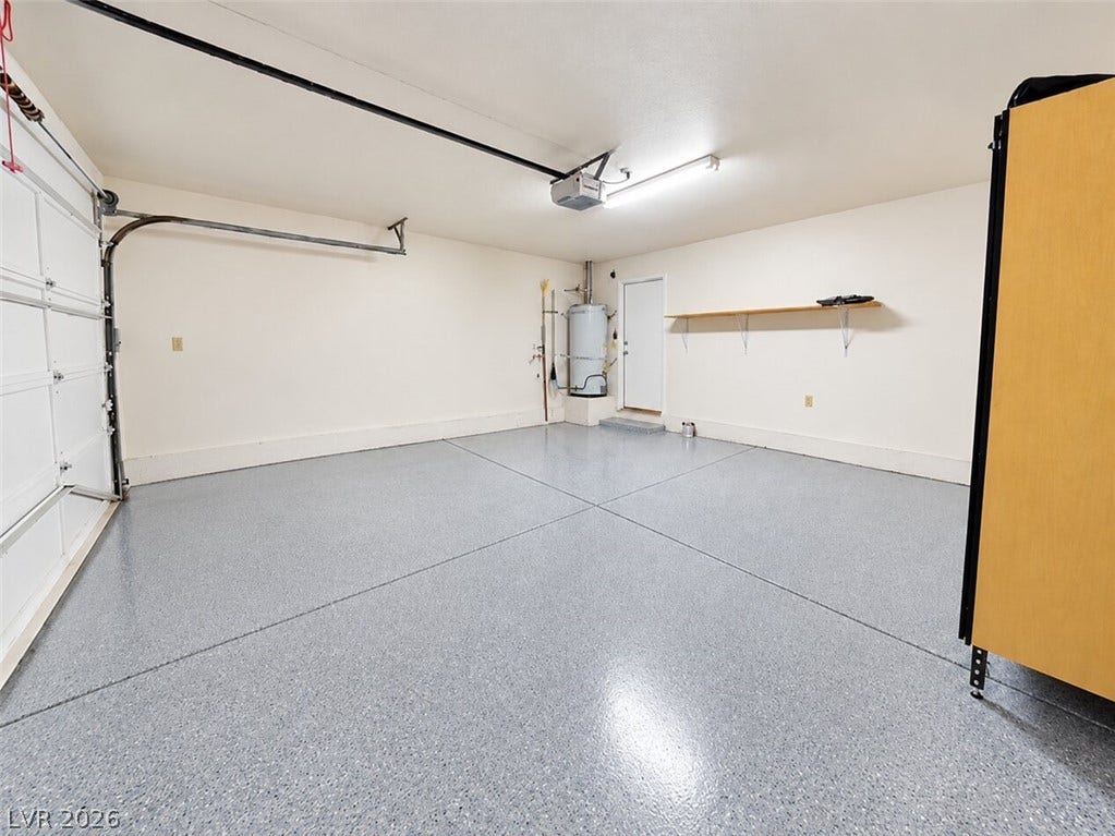 Finished epoxy flooring and built-in shelving maximize the utility of this clean garage space.