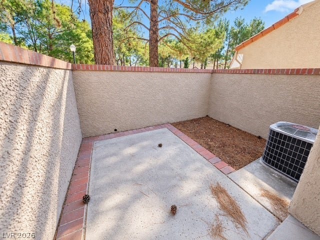 A private walled patio offers a quiet outdoor retreat framed by mature pine trees.