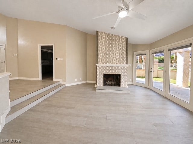 A spacious living area anchors around a floor-to-ceiling tiled fireplace and transition steps.