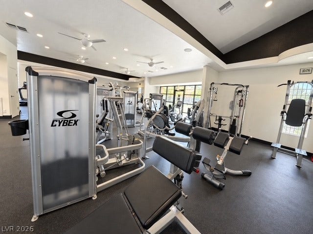 Professional fitness center features multiple exercise stations under recessed lighting and vaulted ceilings.