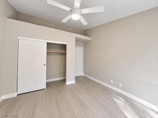 Smooth wood floors anchor this clean, minimalist bedroom featuring high ceilings.