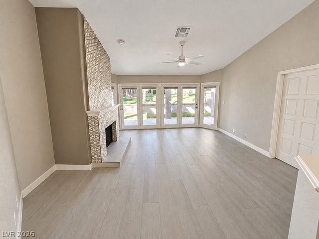 A decorative tiled fireplace anchors this open living space featuring vaulted ceilings and patio access.