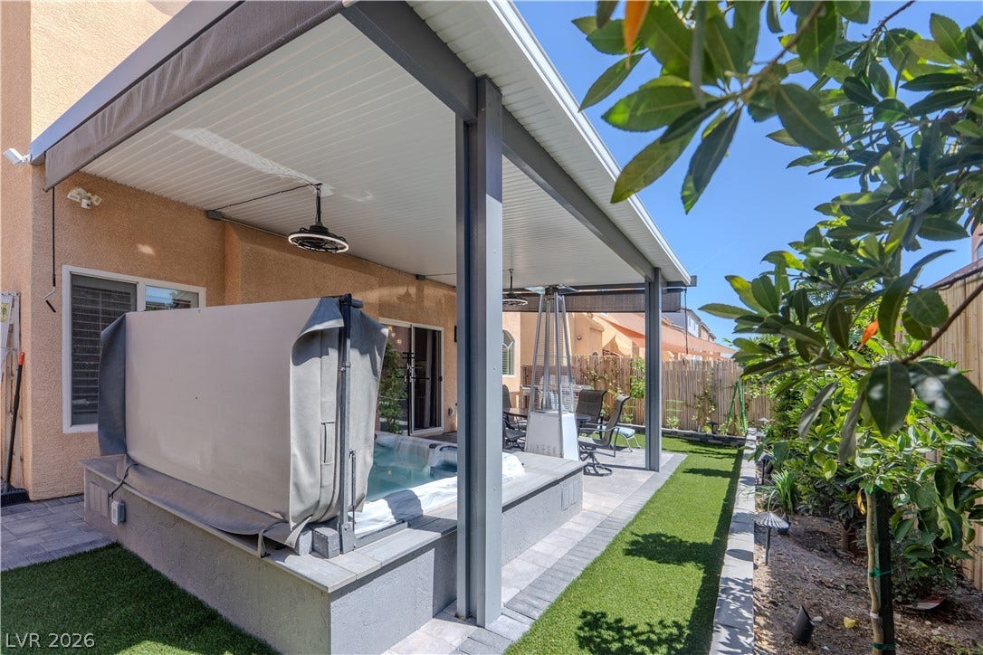 6007 Sonoma Station Avenue, Las Vegas, NV 89139 An inviting covered patio offers a built-in spa alongside a manicured lawn area.