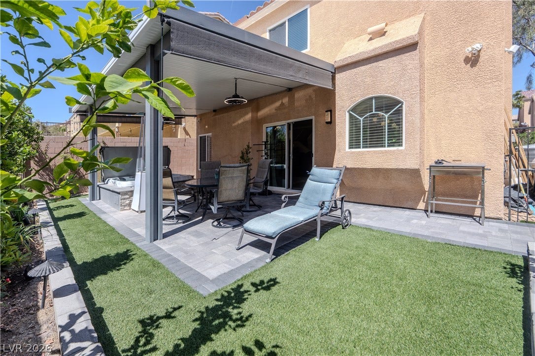 6007 Sonoma Station Avenue, Las Vegas, NV 89139 An inviting paved patio sits beneath a covered structure adjacent to a neat lawn.