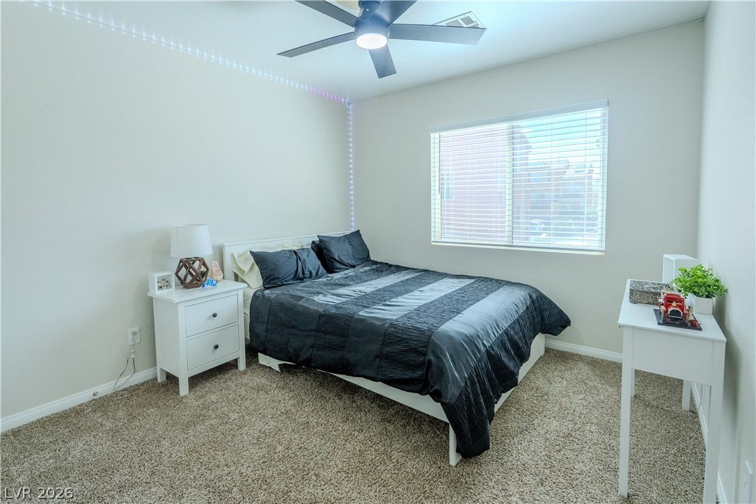 6007 Sonoma Station Avenue, Las Vegas, NV 89139 A sunny window illuminates this carpeted bedroom.