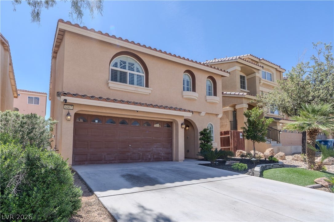 6007 Sonoma Station Avenue, Las Vegas, NV 89139 Spanish tile roofing and arched window details enhance this two-story stucco exterior design.
