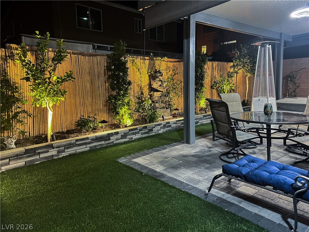 6007 Sonoma Station Avenue, Las Vegas, NV 89139 A stone paver patio sits adjacent to a manicured lawn under a covered structure.
