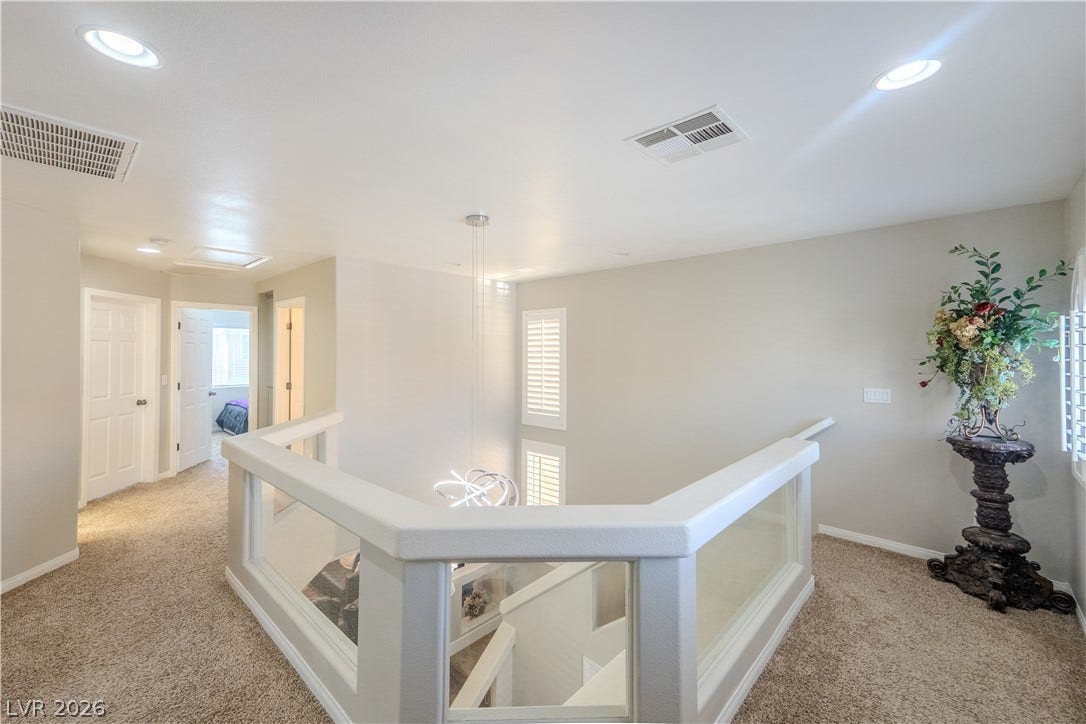 6007 Sonoma Station Avenue, Las Vegas, NV 89139 Plush carpeting and an elegant overlook define this airy upper level hallway.