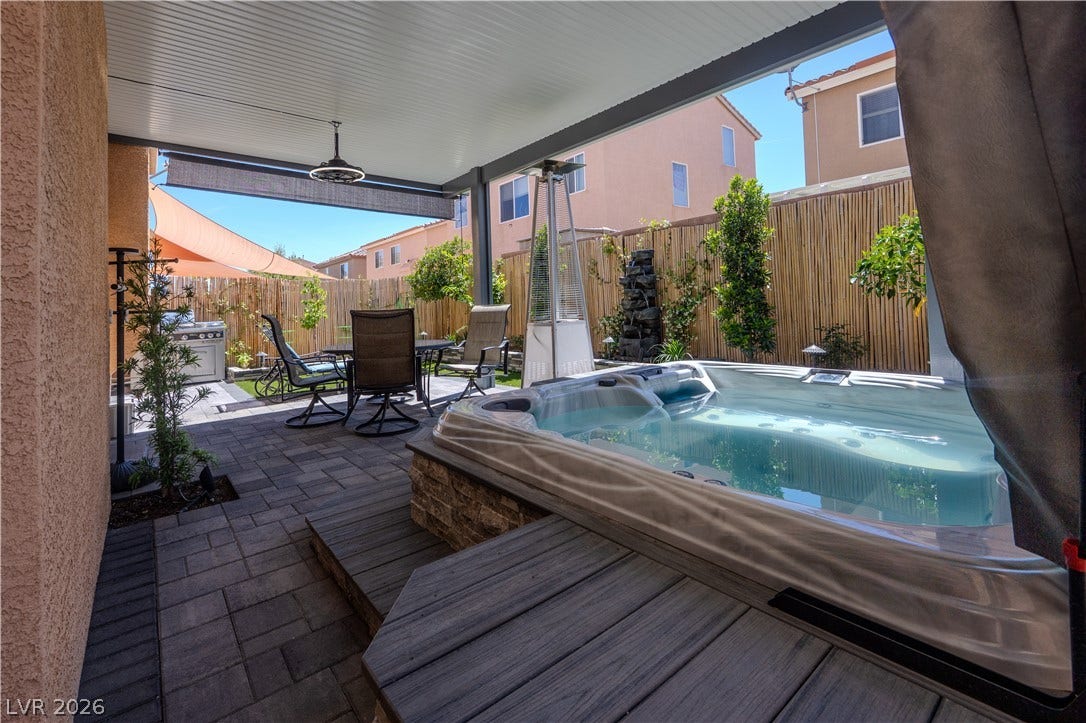6007 Sonoma Station Avenue, Las Vegas, NV 89139 An inviting backyard retreat features structured stone pavers and a built-in spa under a covered patio.