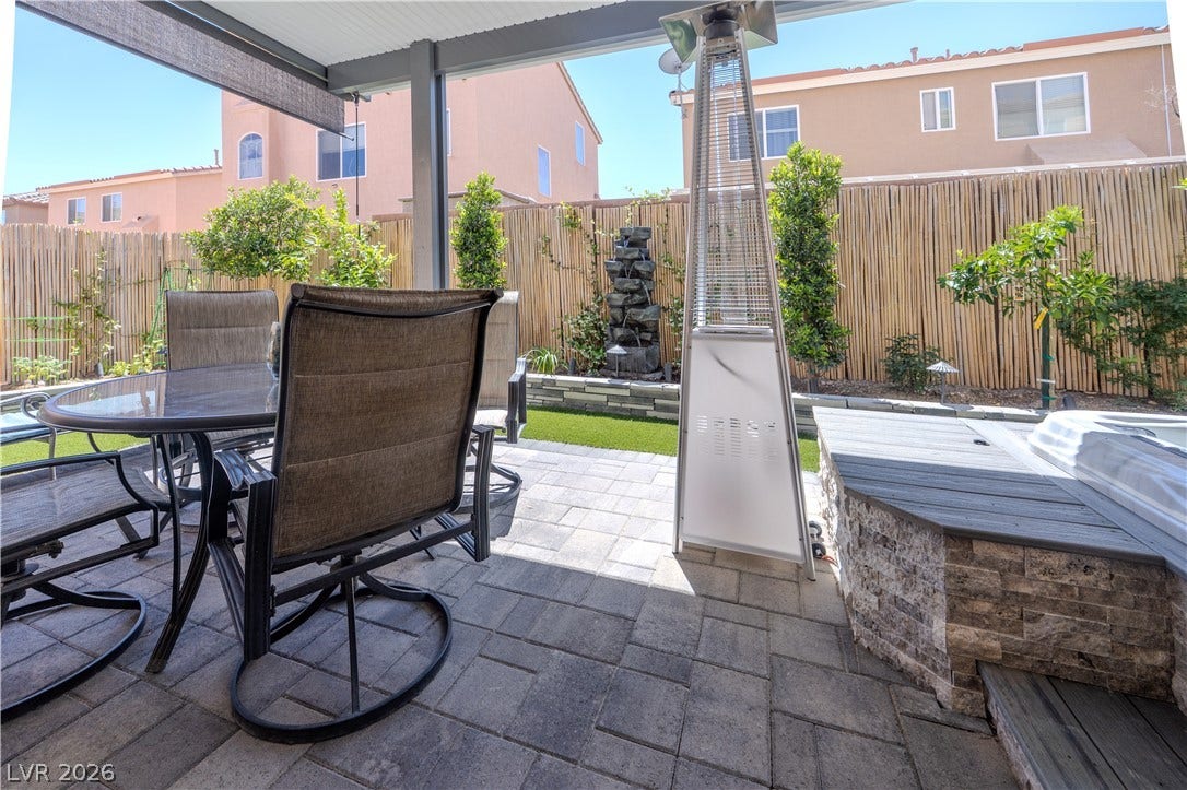 6007 Sonoma Station Avenue, Las Vegas, NV 89139 A stone-paved patio connects a sheltered seating area with the private yard beyond.