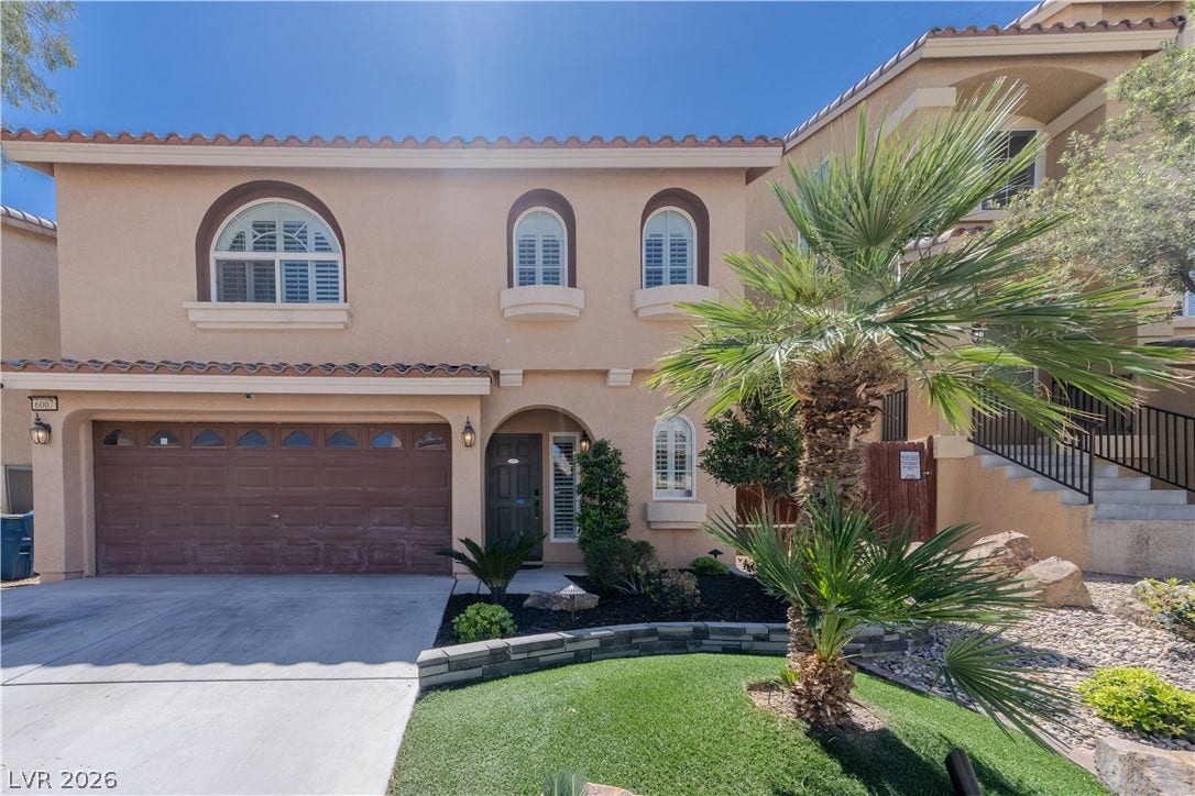 6007 Sonoma Station Avenue, Las Vegas, NV 89139 Mediterranean-inspired stucco architecture frames the entrance, complete with arched windows and manicured landscaping.