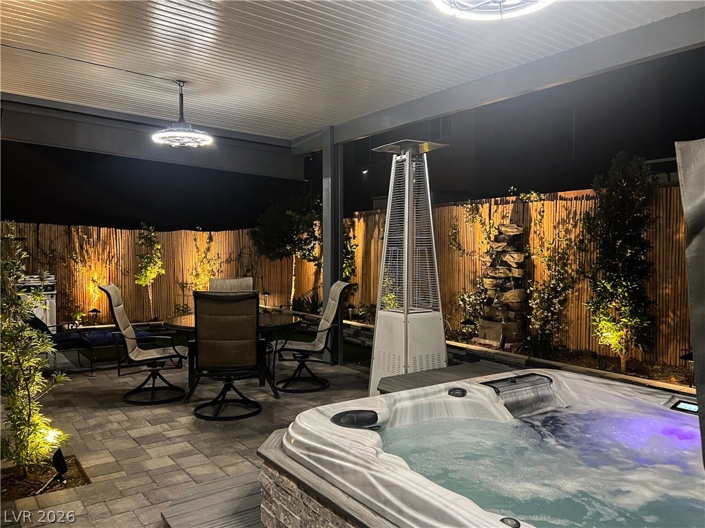 6007 Sonoma Station Avenue, Las Vegas, NV 89139 A covered patio with stone pavers features a built-in spa adjacent to a dining area.