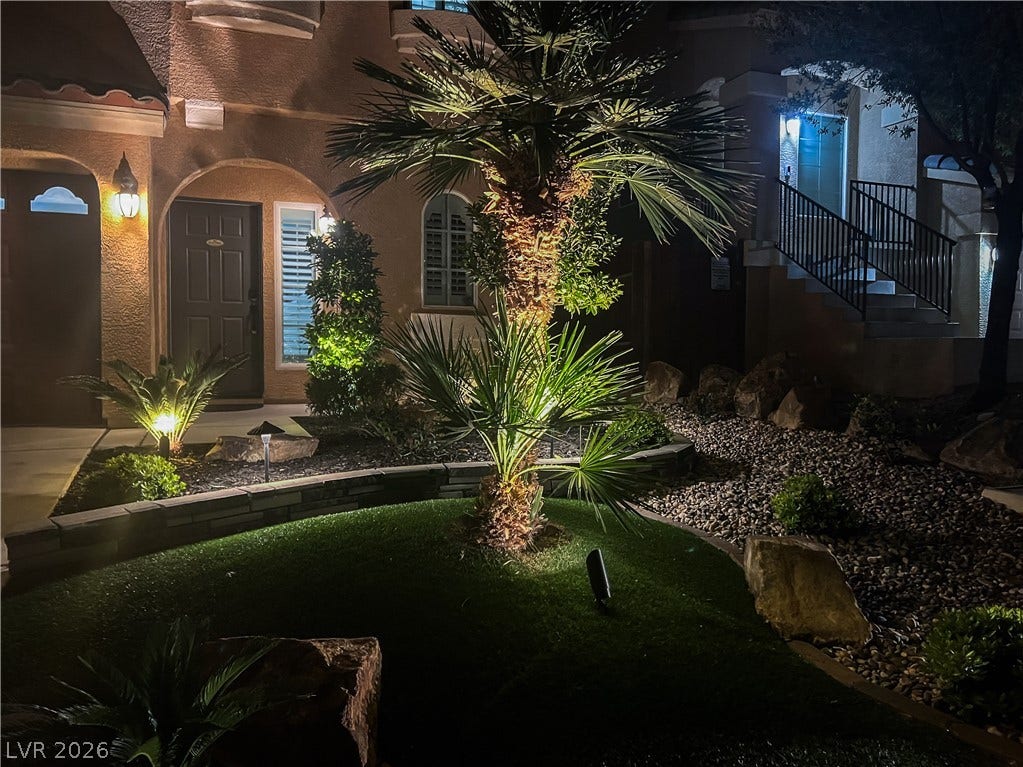 6007 Sonoma Station Avenue, Las Vegas, NV 89139 Lush desert landscaping and warm exterior lighting create an inviting evening entryway.